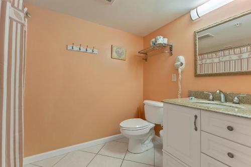 a bathroom with a toilet and a sink and a mirror at Partial Ocean View Condo W Pool & Parking in North Wildwood