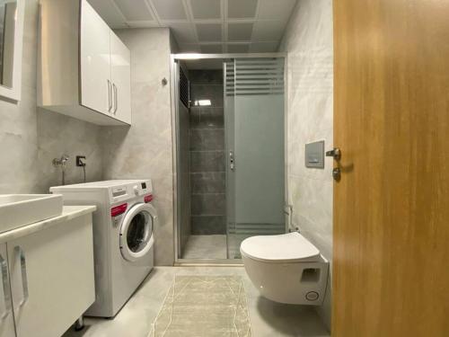 a bathroom with a toilet and a washing machine at Tranquility and Entertainment Combined in Istanbul