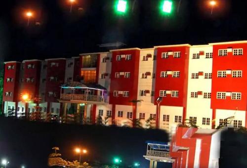 a large red and white building at night at Hotel De Bently - Deluxe in Abuja