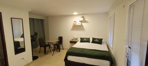 a bedroom with a bed and a table and a desk at CASA HOTEL FLOR DEL VALLE in Cali