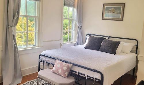 a bedroom with a bed and two windows at Pinetown Bridge Bnb LLC 