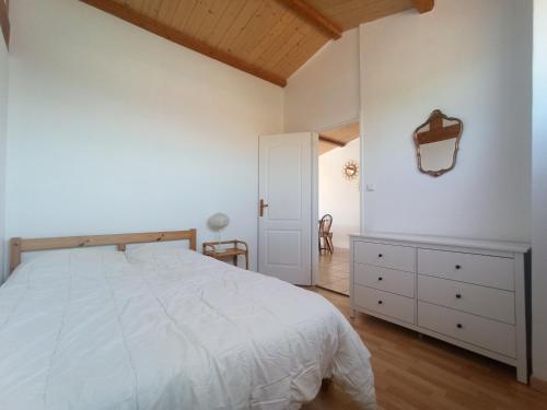 une chambre avec un lit blanc et une commode dans l'établissement Appart'cosy - 7 personnes, à Saint-ouen-dʼAunis