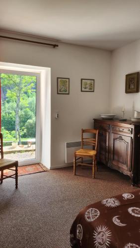 ein Wohnzimmer mit einem Fenster, einem Tisch und Stühlen in der Unterkunft apartment, gite by the canal l Est,river Coney vosges france in Fontenoy-le-Château