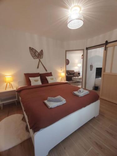 um quarto com uma cama grande com duas toalhas em T2 balnéothérapie, jardin, parking, tram, boulodrome em Blagnac