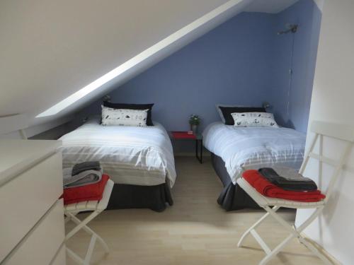 ein Schlafzimmer mit zwei Betten und einer blauen Wand in der Unterkunft Au Quai Des Pecheurs in Straßburg