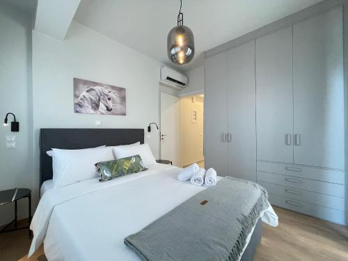 a bedroom with a large white bed and a cabinet at Urban Oasis in Ellinikon - Athenean BnB in Athens