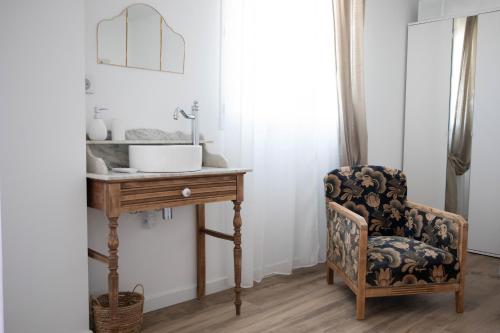 a bathroom with a sink and a chair next to a table at Superbe appartement - L'escapade in Onzain