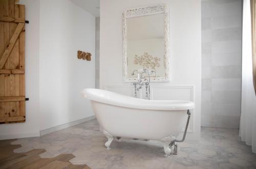 a white bath tub in a bathroom with a tile floor at Superbe appartement - L'escapade in Onzain