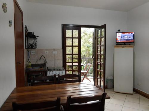 a living room with a kitchen and a television at Recanto do italiano in Ubatuba