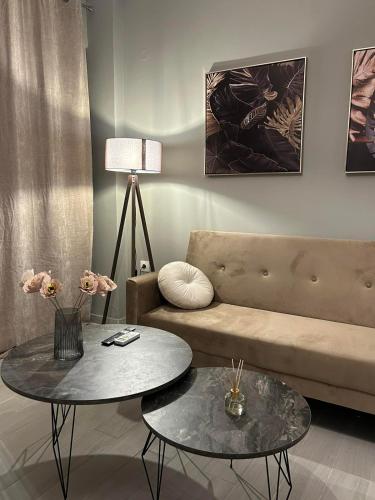 a living room with two tables and a couch at yourcomfortzone*VOLOS in Volos