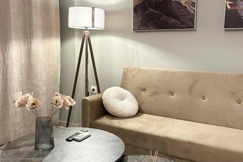 a living room with a couch and a table and a lamp at yourcomfortzone*VOLOS in Volos