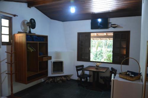 a room with a table and a window and a desk at Pousada Moinho Azul in Teresópolis
