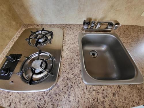 a kitchen counter with a sink and a stove at Moceanset Getaways - Ocean, Mountain & Sunset Views - Cozy Accommodations in Dingwall