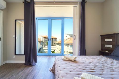 a bedroom with a bed and a large window at Apartamentos Carballal in Palas de Rei