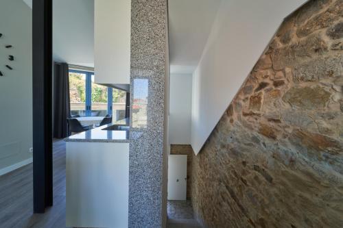 una scala in una casa con un muro di pietra di Apartamentos Carballal a Palas de Rei