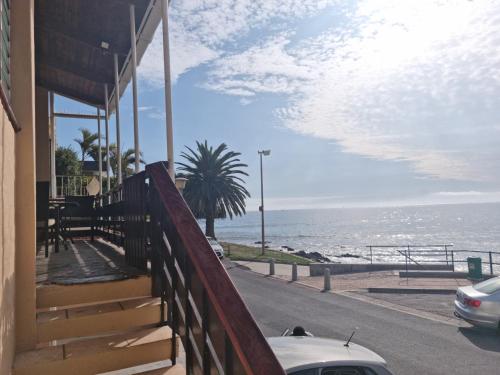a balcony of a house with a view of the ocean at Bikini Beach Holiday Home, On the Beach, Sleeps 9! in Gordonʼs Bay