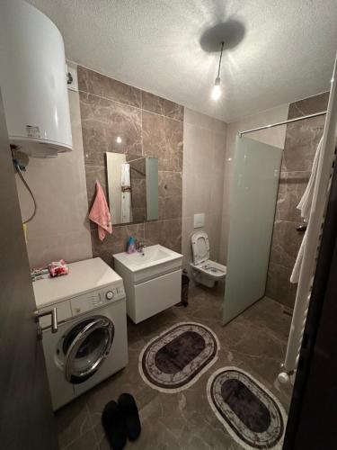 a bathroom with a washing machine and a sink at Modern Apartment in Ferizaj