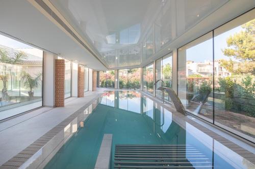 uma piscina interior num edifício com janelas em JS Portocolom Suites em Porto Colom