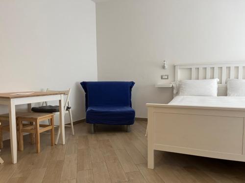 - une chambre avec un lit, un bureau et une chaise bleue dans l'établissement Cristallo di neve b&b, à Roccaraso