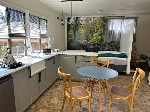 a kitchen with a table and chairs and a bed at Green Cottage in Haenertsburg