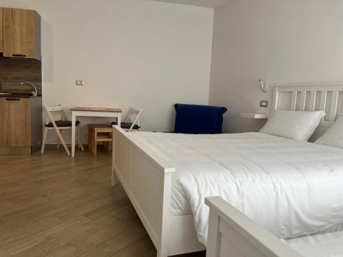 a bedroom with a large white bed and a kitchen at Cristallo di neve b&b in Roccaraso