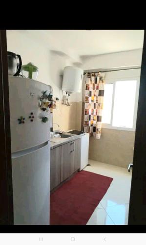 uma cozinha com um frigorífico branco e uma janela em Appartement calme au centre em Oujda