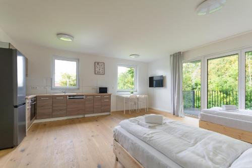 a large white room with two beds and a kitchen at T&K Apartments - Bergisch Gladbach - 7 Comfortable Apartments - 20 min to Fair Messe Cologne in Bergisch Gladbach
