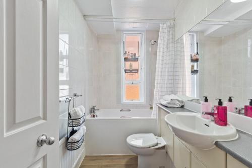 a white bathroom with a sink and a toilet at Oxford Street London Apartments Hosted by Maysa in London