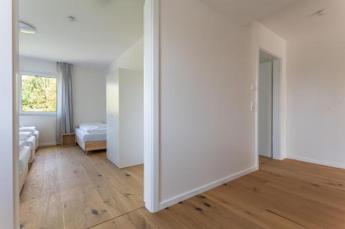 um quarto com paredes brancas e piso de madeira em T&K Apartments - Bergisch Gladbach - 7 Comfortable Apartments - 20 min to Fair Messe Cologne em Bergisch Gladbach