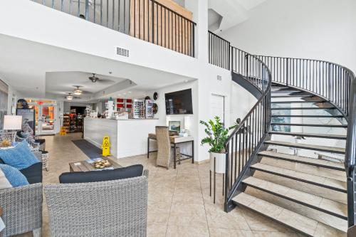 a spiral staircase in a living room with chairs at Calypso Beach Resort & Towers by Panhandle Getaways in Panama City Beach