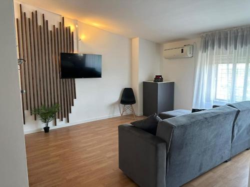sala de estar con sofá y TV de pantalla plana en Nataly Home en Montesilvano Marina