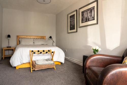 een slaapkamer met een bed, een stoel en een bank bij Nr WINDSOR stunning 1 bedroom self contained property in Burnham near Heathrow in Burnham