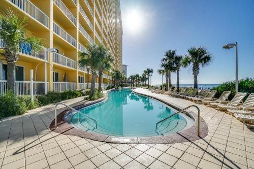 a swimming pool in front of a building with palm trees at Calypso Beach Resort & Towers by Panhandle Getaways in Panama City Beach