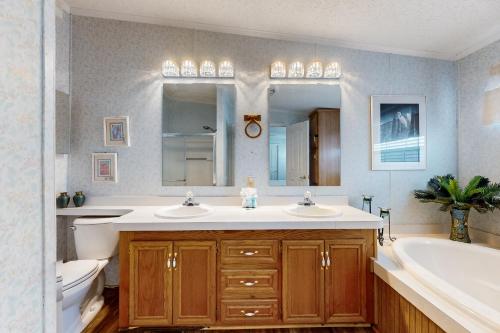 a bathroom with two sinks and a tub and a toilet at Laguna Hideaway in Panama City Beach