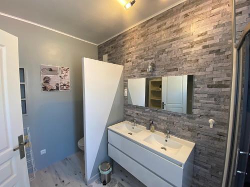 a bathroom with a sink and a brick wall at Villa Liliane appartement de 55 m2 in Mers-les-Bains