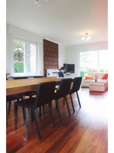 a dining room with a wooden table and chairs at Holiday home Zelenachten in Zele
