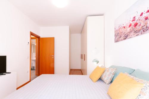 Habitación blanca con cama y TV en DOR'MICHI', en Trento