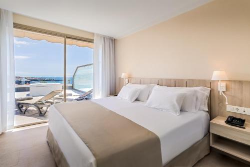 1 dormitorio con 1 cama blanca grande y balcón en Barceló Santiago - Adults Only, en Puerto de Santiago