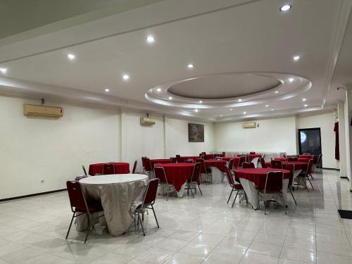 uma sala de jantar com mesas e cadeiras vermelhas em Hotel Winong Asri em Pati