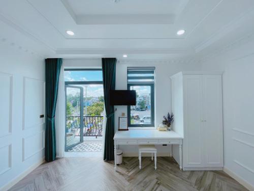 a white room with a desk and a window at Paris Hotel & Cafe in Vĩnh Long