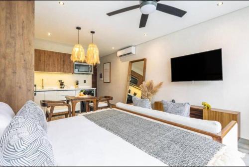 um quarto com uma grande cama branca e uma cozinha em Modern Urban Jungle with Luxury Mayan Style em Tulum