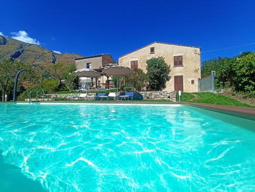 a pool of blue water in front of a house at Casa del Sole in Polizzi Generosa