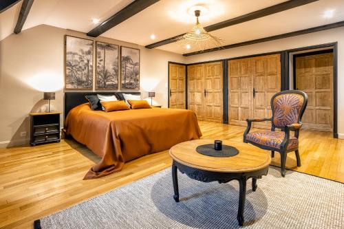 - une chambre avec un lit, une table et une chaise dans l'établissement les bois de ravel chambres d'hôtes, à Ravel