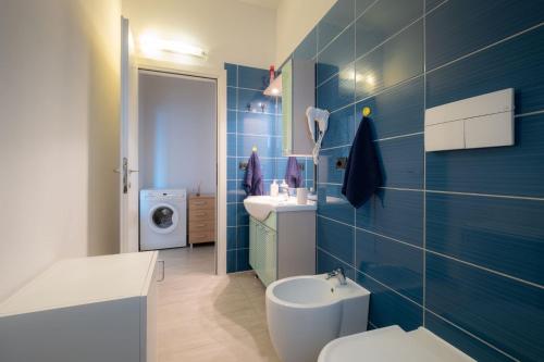 a blue bathroom with a toilet and a sink at BILOCALE FRONTE MARE in Rimini