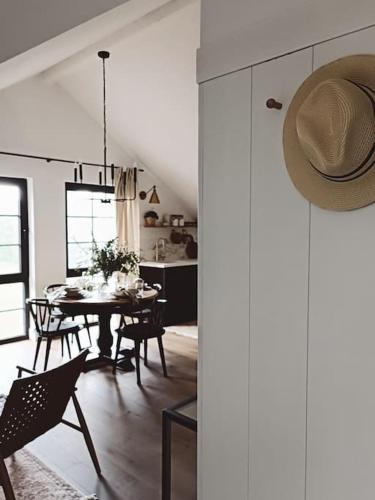 a dining room with a table and chairs and a hat at Gemütliches Appartement im Kottenforst Nähe Bonn in Meckenheim