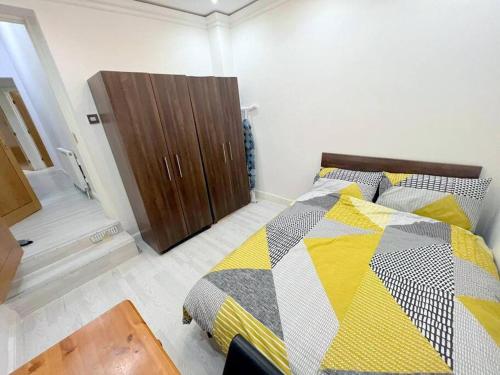 una camera con letto e armadio in legno di 2-bedroom Apartment in Tooting a Londra