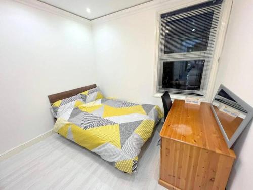 una camera con letto, scrivania e finestra di 2-bedroom Apartment in Tooting a Londra