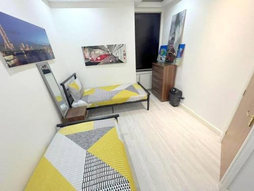 una camera con un letto e un comò di 2-bedroom Apartment in Tooting a Londra