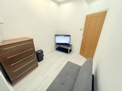 a living room with a couch and a television at 2-bedroom Apartment in Tooting in London