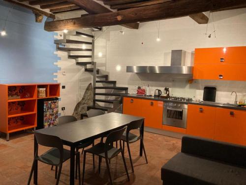uma cozinha com uma mesa e cadeiras e uma escadaria em CASA GINESTRA em Campiglia Marittima